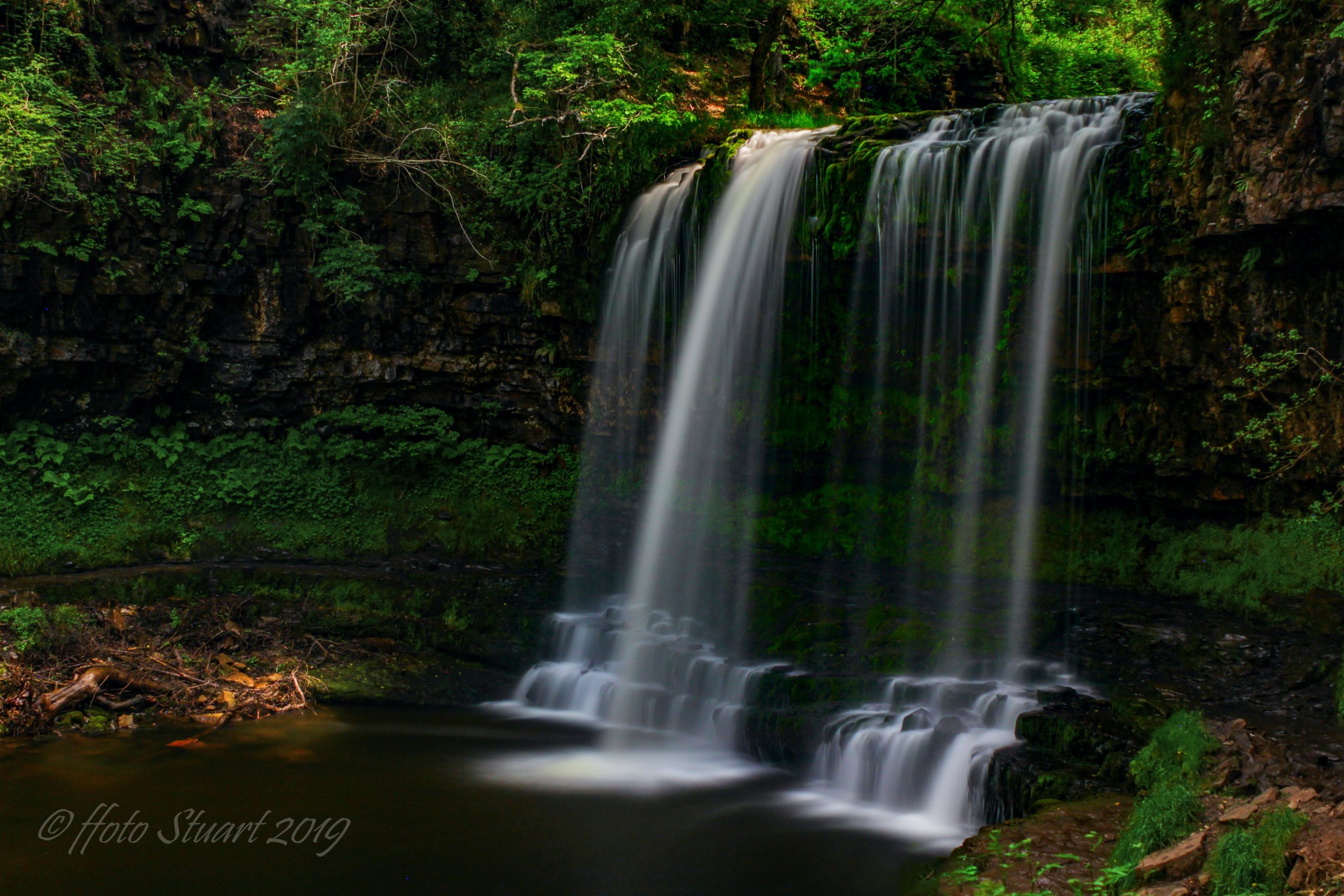 Sgwd yr Eira or Fall of Snow with late afternoon sun bouncing off the water. A long exposure captures the power and delicacy of the falls.