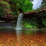 Sgwd Gwladys or Lady Falls with sunlight reflecting off the pool of water.